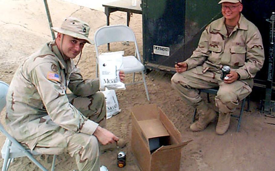 Sam Newland, left, of the Natick Soldier Center tests a Meal, Cold Weather (MCW) ration in 115-degree weather in Iraq in June 2003. New menus for the MCW and Food Packet, Long Range Patrol rations have been developed with the help of solider taste-testers.