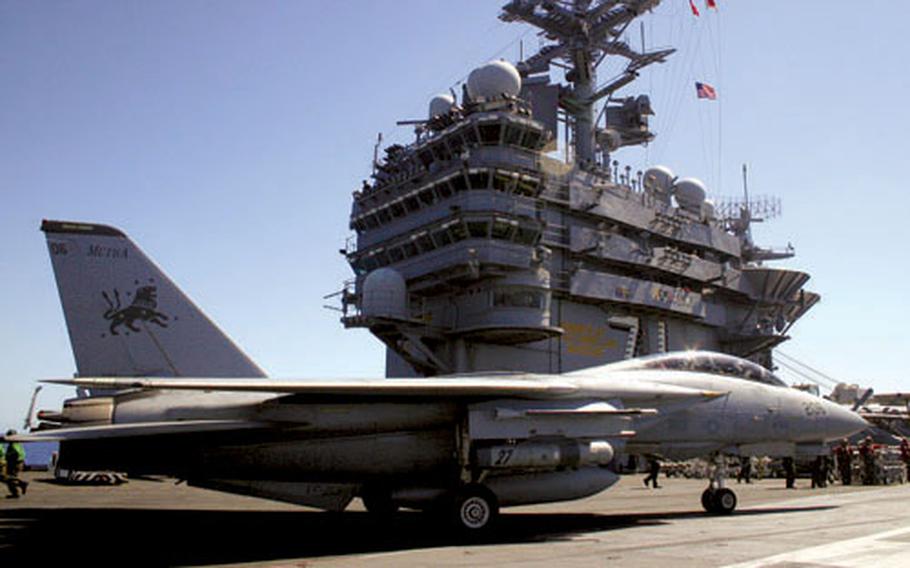 An F-14 Tomcat taxis by “the island” of the USS Theodore Roosevelt on Sept. 10, 2005, after landing moments earlier. The Tomcat is retiring for good after having flown its final mission in Iraq on Feb. 8.