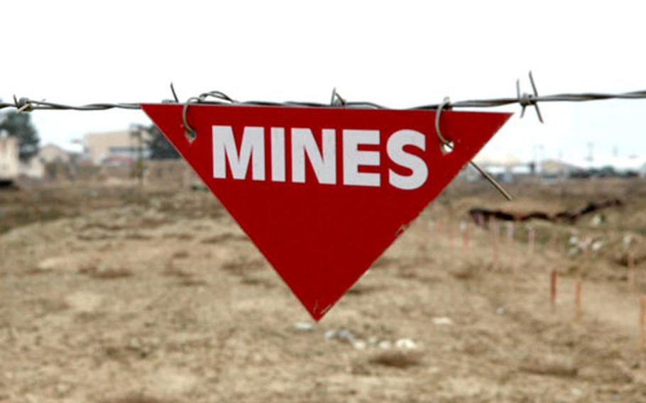 Red flags mark areas on Bagram Air Base, Afghanistan, where members of a Polish demining team search for mines and old ordnance used as bombs. As many as 20 million mines are scattered across the country.