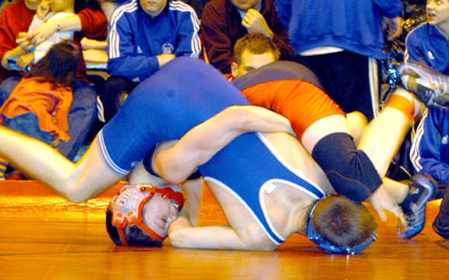 Lakenheath’s Kyle Tyree, in black and red, spars with London Central’s Hugh Borchers during a 125-pound weight class bout in Lakenheath’s gym on Feb. 4. Tyree pinned Borchers in 3 minutes, 14 seconds.