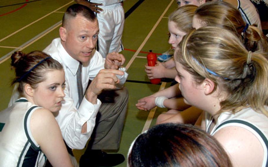 Alconbury coach Ron Davis goes over a game plan with his Lady Dragon players during a game against London Central.