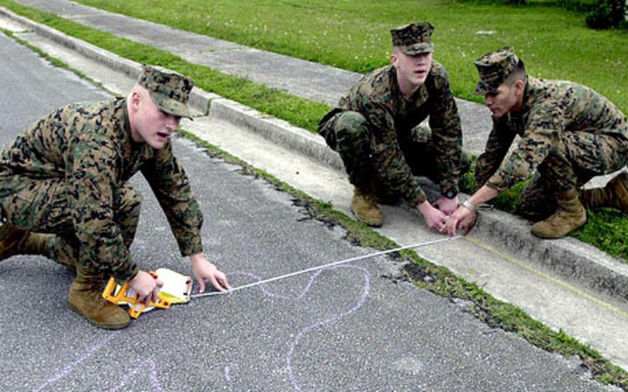 From left, Lance Cpls. Christopher Taylor and Paul Johnston and Cpl. Daniel Martinez take measurements of a mock fatal vehicle accident scene. The Marines are all military policemen and are taking part in an accident investigators course on Camp Foster, Okinawa.