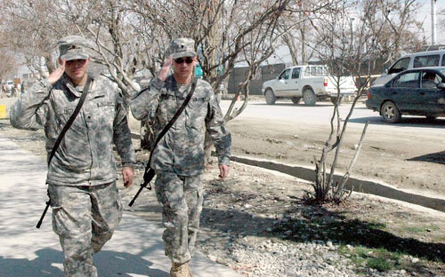 Soldiers walking along Disney Drive on Bagram Air Base return salutes.