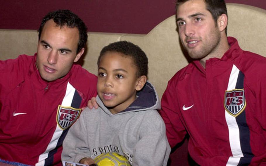Landon Donovan, left, and Carlos Bocanegra, of the U.S. men’s soccer team, pose with Weston McKennie, 7, at Ramstein Air Base, Germany, on Monday. The U.S. plays Poland in a friendly match at Fritz-Walter Stadium in Kaiserslautern, Germany, on Wednesday.