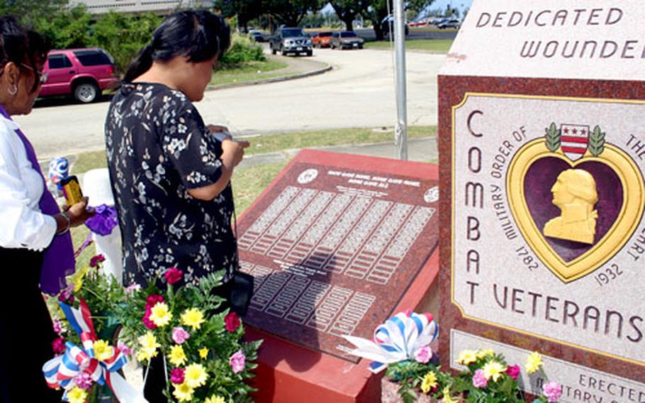 Deanna Payas, left, and her niece Teresita Gleason find the names of relatives on the just-dedicated Purple Heart Memorial in Hagatna, Guam.