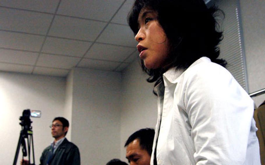 Real estate agent Takako Niikura asks Yokosuka Naval Base officials a question Tuesday about the new off-base housing initiative.