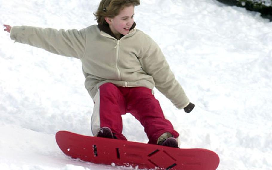 Neely O’Grady, 8, works the extreme edge of her snowboard on a slope below the conference center at H.D. Smith Barracks in Baumholder, Germany. The base got about 8 inches of snow overnight Wednesday.