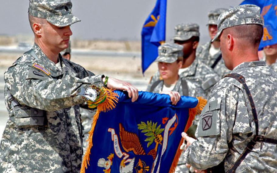 Lt. Col. Mark Patterson, left, and Command Sgt. Maj. Thomas Gordon unfurl the colors of the 2nd Battalion (Assault), 10th Aviation Regiment during a transfer of authority ceremony Saturday at Kandahar Airfield, Afghanistan.