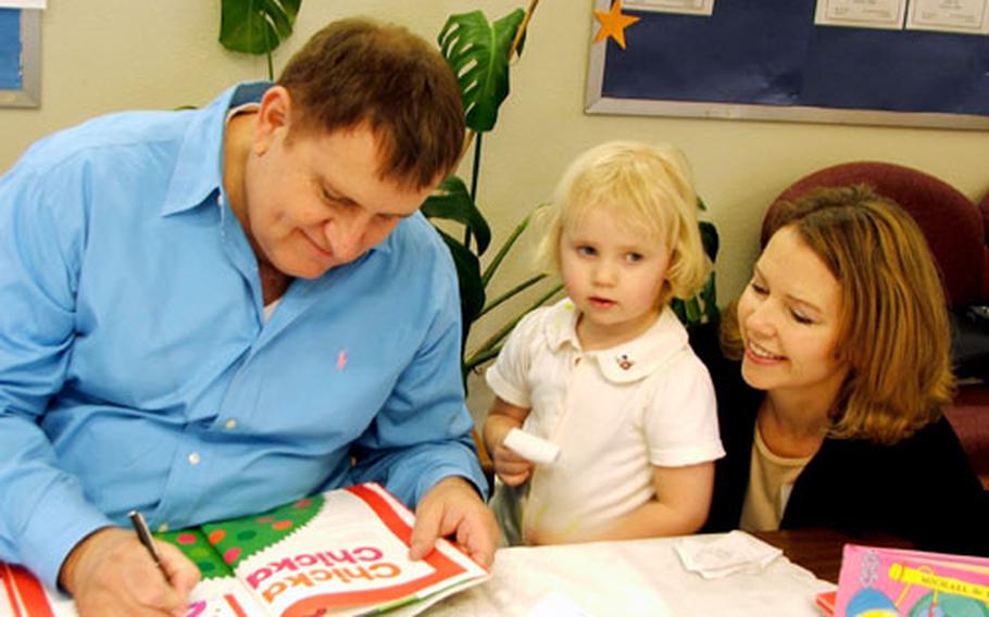 Michael Sampson signs a copy of “Chicka, Chicka 1 ... 2 ... 3” for Rebeka Wuerch, 3, and her mom, Miryam. The book is one of the best-sellers Sampson wrote with his late writing partner, Bill Martin Jr.