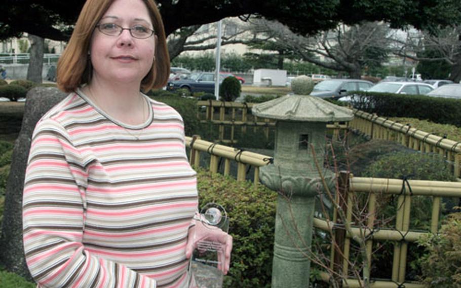 Marnie Goodman, Regional Housing Director for Naval Air Facility, Atsugi, earned the top Navy award for a housing director in her category, after her first year on the job. She is now implementing a $20 million housing revitilization at Atsugi. Goodson holds the crystal award she received last month from the Navy.