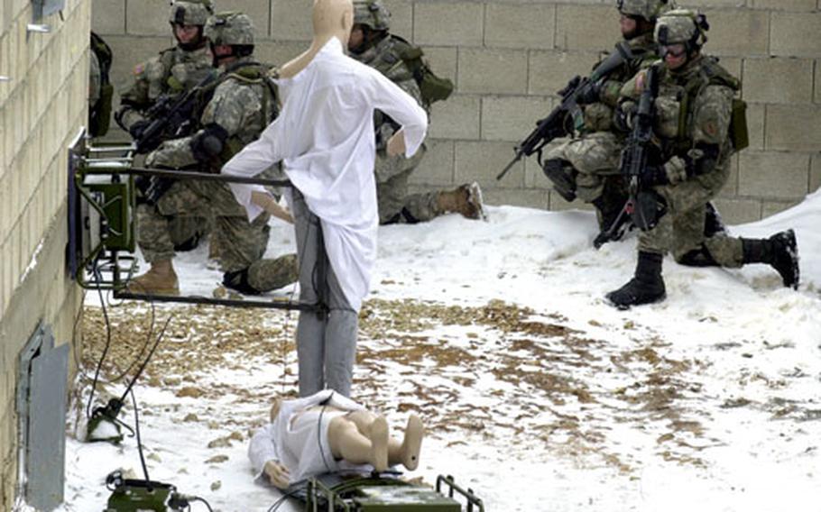 Soldiers from the 1st Battalion, 18th Infantry Regiment regroup after taking out a pair of mannequins with simunitions Monday at Hohenfels, Germany.