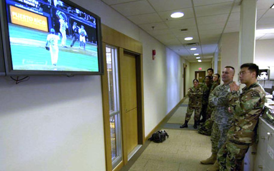 Members of the 8th U.S. Army, including South Korean Augmentees to the U.S. Army, gather Tuesday to watch the South Korean and American baseball teams go head-to-head.