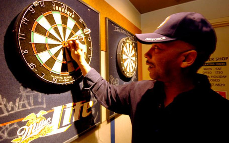 Ron Harmon, a civilian contractor with the 374th Communications Squadron, throws darts Tuesday afternoon at the enlisted club on Yokota Air Base, Japan.