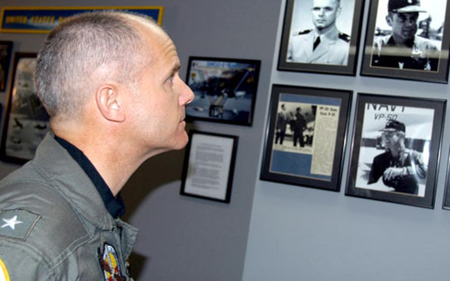 /Rear Adm. Brian Prindle, commander of Patrol and Reconnaissance Group in Norfolk, Va., views photographs and news clippings of his late father.