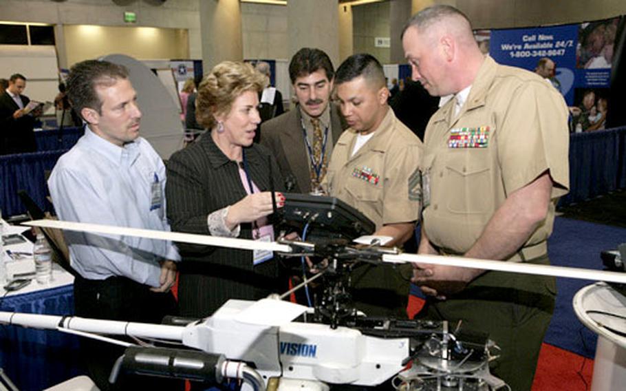 Chief Warrant Officer Michael Childs, right, Gunnery Sgt. Eulalio Ruiz III and others look at a gyro-stabilized platform after the Marines received the U.S. Naval Institute Copernicus Award in San Diego.