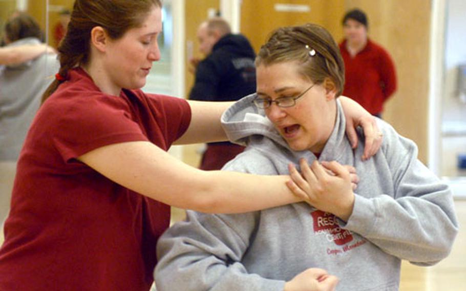 Maaret Ingram, right, practices an escape move on Camille Cruzan, during a women's self-defense class at RAF Mildenhall.