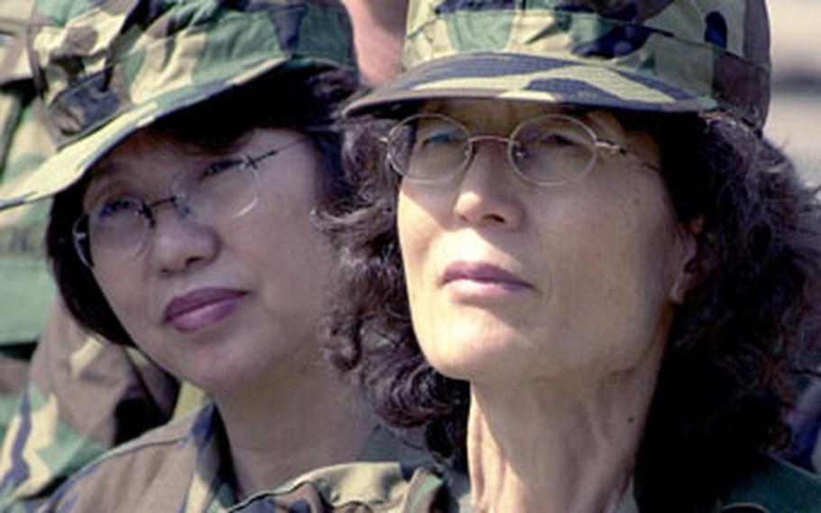 Civilian employees, decked out in camouflage uniforms, listen to a training session in Seoul on Tuesday.