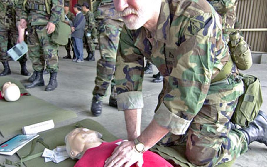 Ilmar Tarikas works on a training dummy at a first-aid station Tuesday in Seoul.
