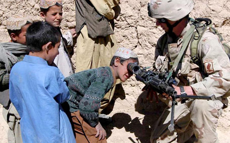 Spc. Steven Haynes of Company B, 2nd Battalion, 503rd Infantry Regiment, 173rd Airborne Brigade lets local children take a look through the scope of his weapon on a recent patrol near Forward Operating Base Lagman, Afghanistan. The 503rd is wrapping up its year-long deployment to the country.