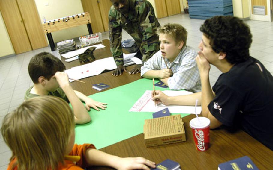 Petty Officer 2nd Class William Groomes, a 10-year Navy veteran and father of two, helps Gaeta kids during the Fatherhood and the Family section of the base’s Passport to Manhood program recently. The program, which started in February and runs through early May, helps kids learn about everything from health issues to job interviews.