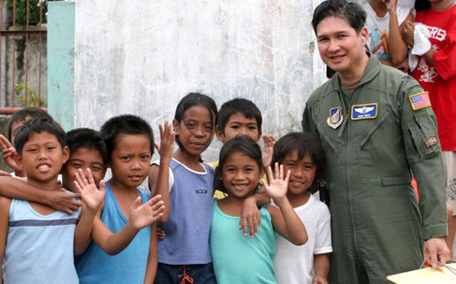 Air Force Col. John T. Cinco, a doctor, is greeted by several children in Saint Bernard in the Philippines on Feb. 23. Cinco, who was raised in the Philippines, is a member of a special international health unit Pacific Air Force maintains to assist in aid missions.