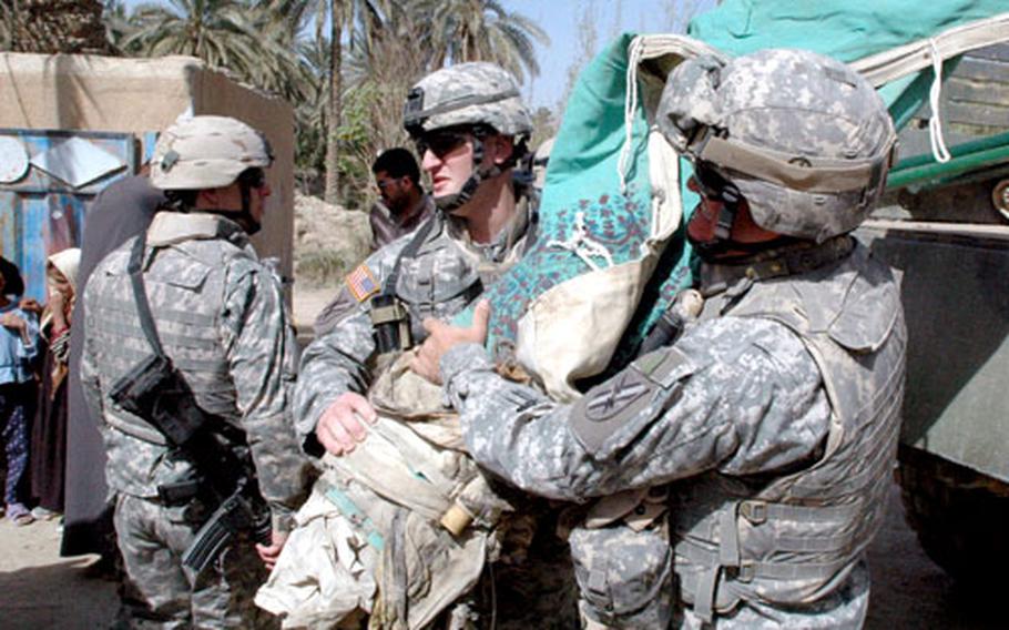 Capt. Rod Tatum with the 48th Brigade Combat Team helps unload a gift of tents during a civil affairs mission near Camp Scania recently. Tatum oversees public works projects such as the construction of water pumping stations, schools and medical clinics.