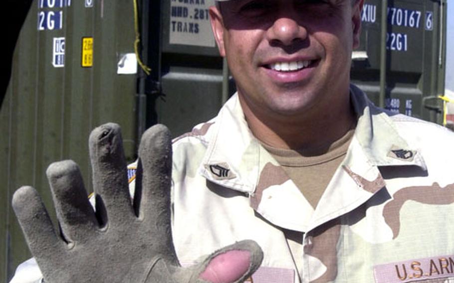 Army Staff Sgt. Eliezer Silva, with the 28th Transportation Battalion out of Mannheim, Germany, shows what the Kuwati heat can do to a leather glove.