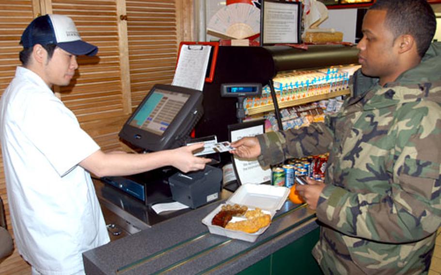 Senior Airman Keith Logan, of the 35th Aircraft Maintenance Squadron, grabs lunch to go Wednesday at Grissom Dining Facility on Misawa Air Base, Japan. Faced with a tight budget for the rest of the fiscal year, to save money the 35th Services Squadron recently limited takeout meals to uniformed military personnel.