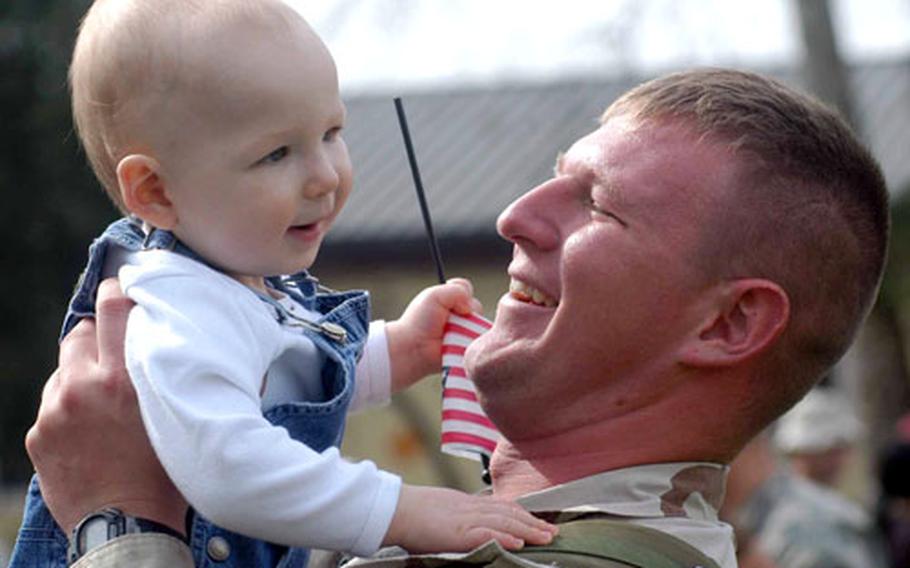 Staff Sgt. Jeremy Scribner, of 2nd Battalion, 503rd Infantry Regiment, 173rd Airborne Brigade, gets a good look at his son Reagan, 1, after returning to Vicenza, Italy, after a year's deployment to Afghanistan. Reagen was born just before his dad's deployment began.