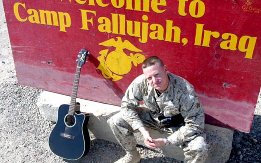 Mike Corrado, and Infantry/operations officer, sits with his acoustic Takamine at the entrance of Camp Fallujah, Iraq.