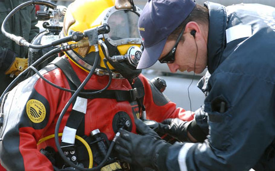 Navy diver Joseph T. Moebius Jr. gets a final safety check before diving in waters off the west coast of South Korea on Wednesday in search of the wreckage of an Air Force F-16 fighter plane that crashed March 14. Moebius is aboard the USS Safeguard, a rescue-and-salvage ship that took part in the search.
