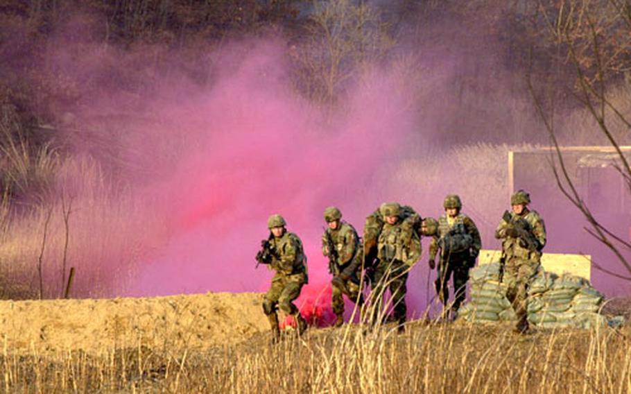 Soldiers from the 4th Stryker Brigade Combat Team, based in Fort Lewis, Wash., evacuate a soldier after storming a terrorist compound in a mock exercise at Rodriguez Range, South Korea, on Thursday.