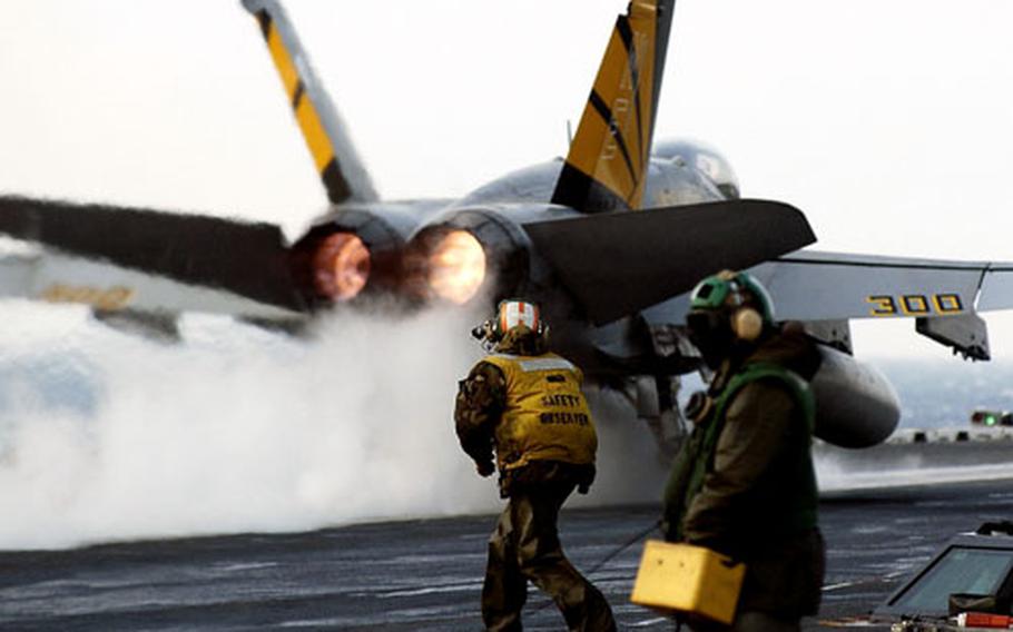 An F/A-18F Super Hornet launches from the flight deck of the Nimitz-class aircraft carrier USS Abraham Lincoln during a snow storm.