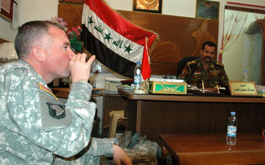 Lt. Col. Thomas Fisher drinks tea and talks about security in Khalis with a local Iraqi army commander.
