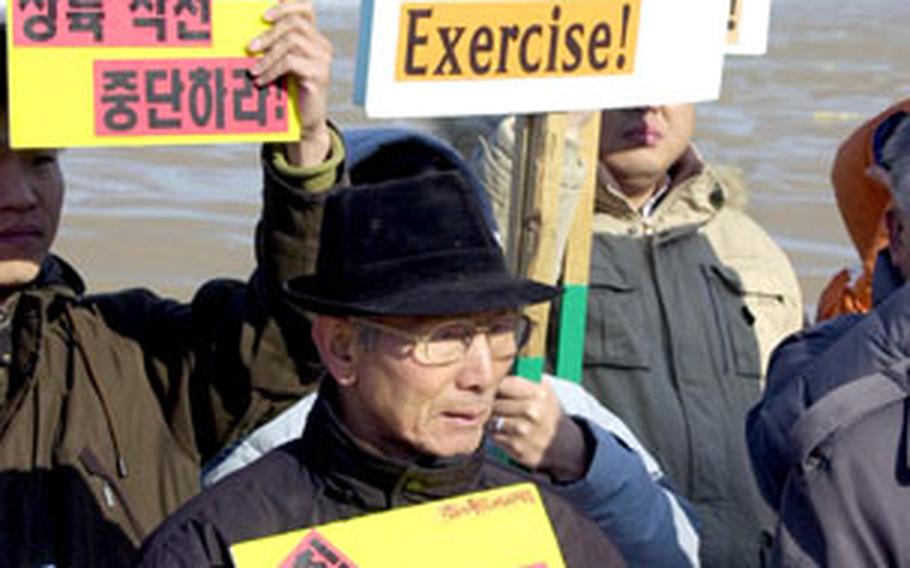 A small group of protesters gathers before a beach assault exercise on Malipo Beach, South Korea, Thursday.