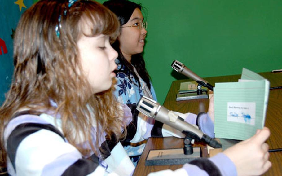 Shelby Johnson, left, and Jennifer Eyink go over the day’s announcement prior to Monday morning’s CNBC broadcast.