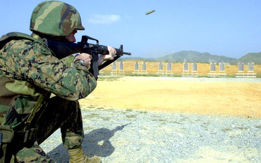 Capt. Ethan Featherly, a KC-130 pilot with Marine Aerial Refueler Transport Squadron 152, fires at multiple targets from 25 yards at one of Camp Hansen’s ranges. This is part of the “Table 2” training of the annual rifle qualification that was implemented in October 2005. If Marines fail the Table 2 portion, their score for the known distance range is dropped and they become marksmen — the lowest qualification the Corps has.
