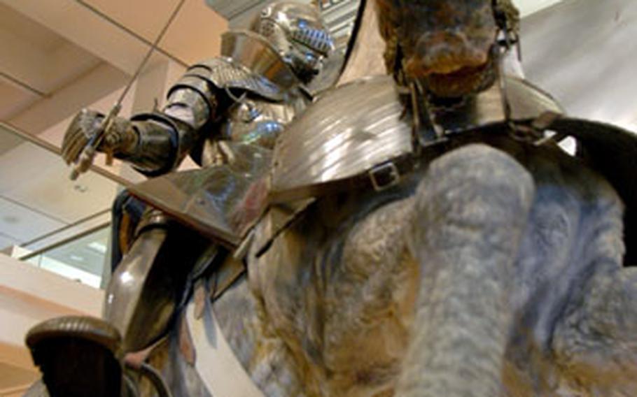 Towering above his opponents, a knight on horseback brandishes a sword in mock battle with peasants.