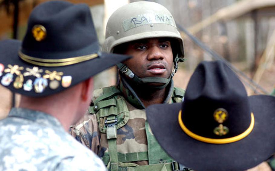 Staff Sgt. Malcolm Coley, center, answers a question posed to him by Spc. Eric Bentley, right as squadron commander Lt. Col. John Peeler listens.