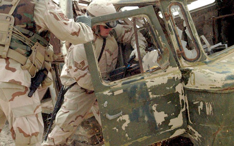 Airmen carry vehicle extraction tools to a simulated crash scene Monday during a training exercise at Ali Base in Iraq.