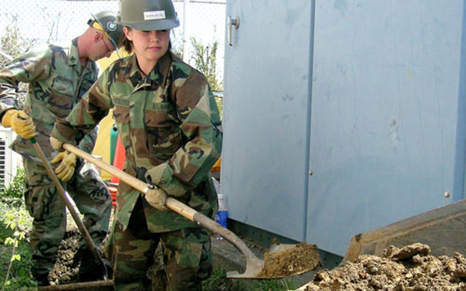 Seabee Apprentice Raymie Huddleston and Petty Officer 2nd Class Matthew Kreamalmyer dig trenches for electric lines on Yokosuka’s Weather Station Hill.