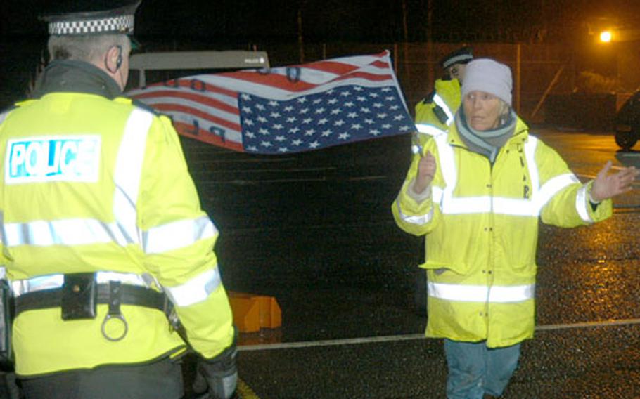 Lindis Percy, right, co-founder of the Campaign for the Accountability of American Bases, quarrels with Ministry of Defence police during a recent demonstration at RAF Menwith Hill, England. A new British law increases the penalty for trespassing on military sites in England and Scotland.