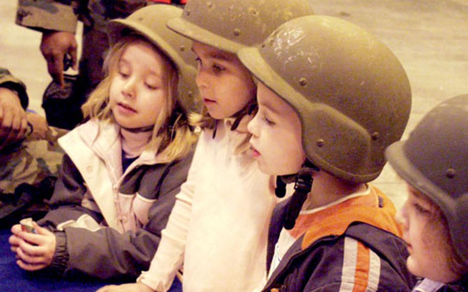 Members of the kids deployed club at Aviano Air Base, decked out in their deployment gear, listen to a briefing on deploying downrange Thursday.