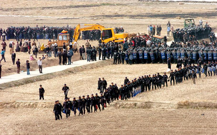 In a contested rice field near Camp Humphreys, South Korea, on Friday, police move into position during a day of clashes with residents opposing a government move to evict them from the area. The South Korean government wants to clear the area of occupants to enable Humphreys to triple in size and become the U.S. military’s main installation on the peninsula.