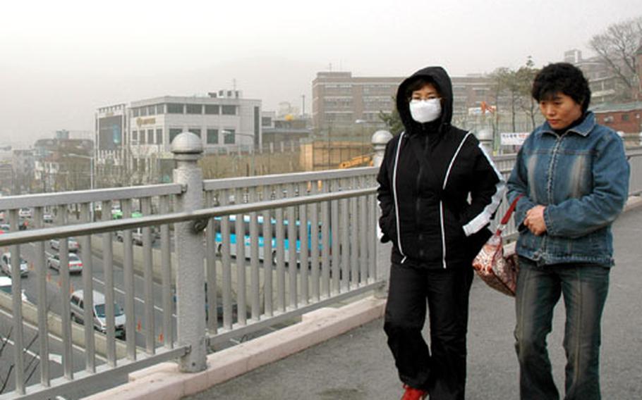 Yellow dust blanketed South Korea on Saturday, obscuring Namsan, or Mount Nam, which would normally be visible in the skyline behind these two women.