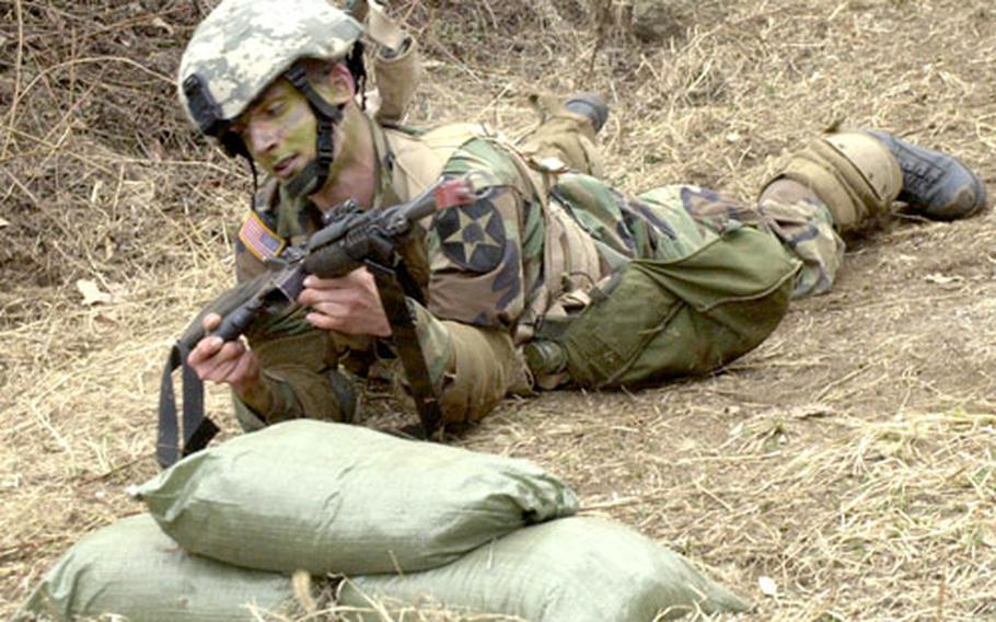 Pfc. Kristopher Williams crawls in the dirt during training for the Expert Infantryman’s Badge at Camp Casey on Thursday.