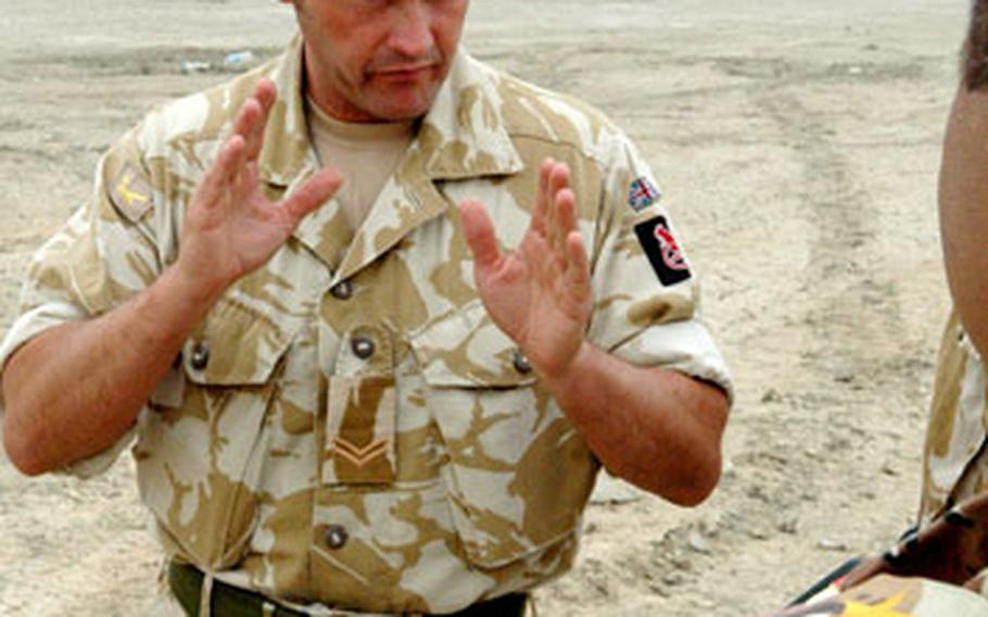 British Army Cpl. Peter Fearon advises an Iraqi army captain and instructor at the Camp Ur Basic Training Center near Nasiriyah recently.