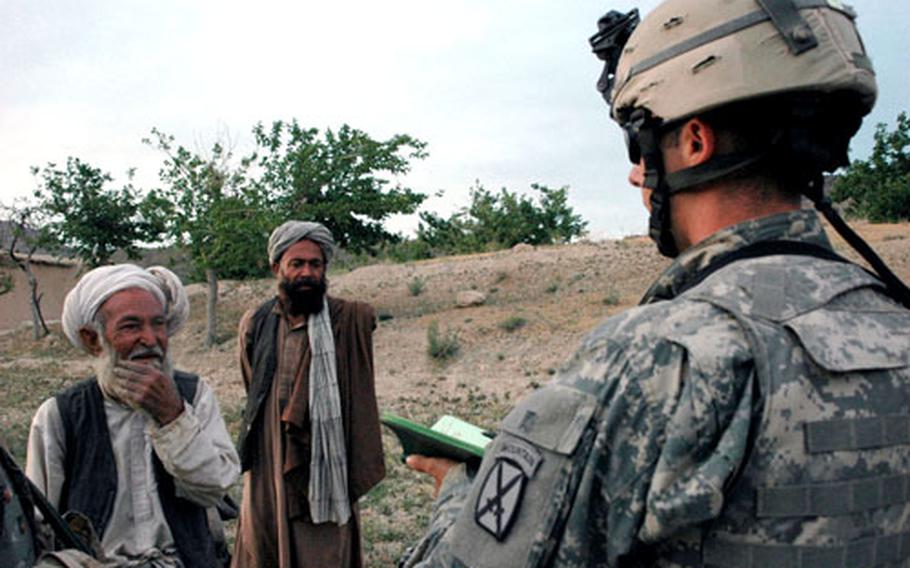 First Lt. James Taddia, a fire support officer for Company A, questions Haji Abdul Rahman, left, a villager who said he was 85 years old. The man and other farmers told the Americans that they don’t pay attention to the outside world. “I just do my planting and field work,” he said.