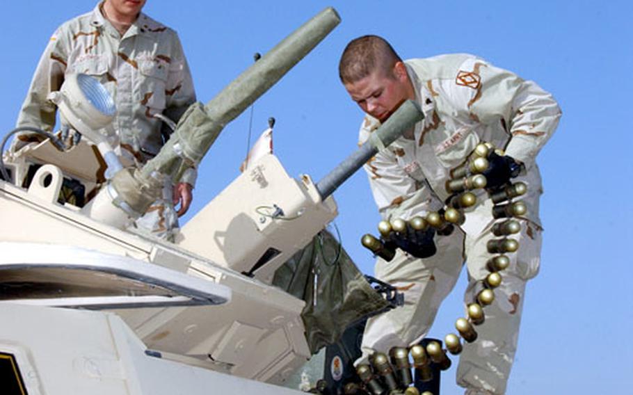 Spc. Eric Davenport, left, and Spc. David Norris, both with Battery C, 1st Battalion, 17th Field Artillery, load grenades into the internal turret of an Armored Security Vehicle.