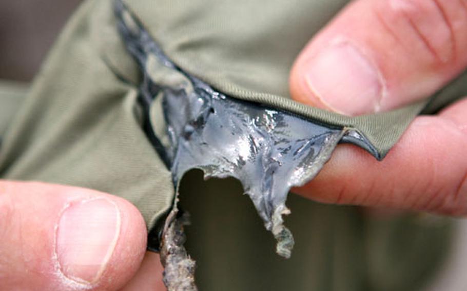A hard crust results from a burn test conducted by Navy Capt. Lynn E. Welling, the 1st Marine Logistics Group’s surgeon, in an effort to study how polyester materials react to fire. Wearing polyester materials, which includes some types of Marine Corps-issued clothing and undershirts, is now prohibited by field commanders for Marines in operations outside the wire in Iraq.
